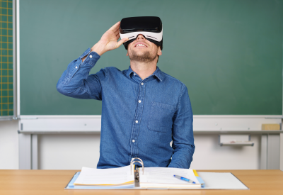 Person im Schulzimmer schaut durch Virtual Reality Brille