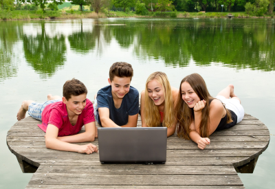 Gruppe Teenager mit Notebook draußen in der Natur