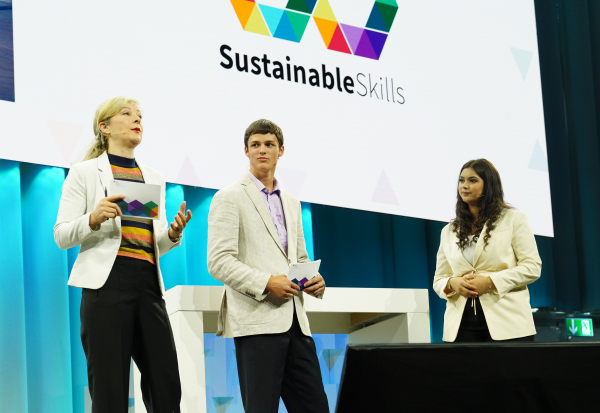 Moderatorin Karin Frei und das Moderationsteam Nouran Wahba und Yanis Ryser auf der Bühne des Kursaals Bern an der EHB-Tagung SustainableSkills am 31. Mai 2022.